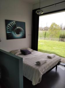 - une chambre avec un lit et une grande fenêtre dans l'établissement Maison d'architecte avec SPA, à Concarneau