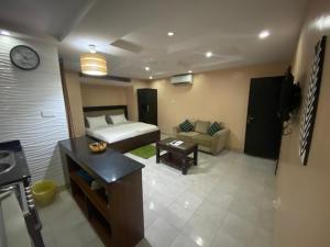 een woonkamer met een bed en een bank bij Studio B, (Studio Apartment) Hillside Gardens in Lagos
