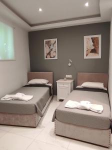 a bedroom with two beds with towels on them at Zen Apartments in Laganas