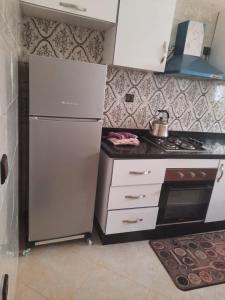 een keuken met een koelkast en een fornuis bij BOUZNIKA in Bouznika