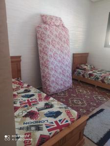 een slaapkamer met 2 aparte bedden en een bed met een kussen bij BOUZNIKA in Bouznika