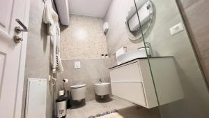 een kleine badkamer met een wastafel en een toilet bij Zeus Tirana Suite in Tirana +22 foto's