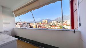 een kamer met een raam met uitzicht op de stad bij Zeus Tirana Suite in Tirana