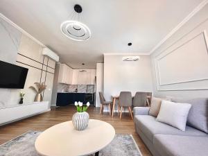 een woonkamer met een bank en een tafel bij Zeus Tirana Suite in Tirana