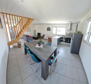 cocina y sala de estar con mesa de madera y sillas en Le Fort des Sables, en Ambleteuse