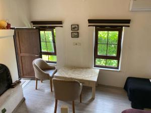 ein Wohnzimmer mit einem Tisch und Stühlen sowie 2 Fenstern in der Unterkunft Old town castle house-detached house in Marmaris