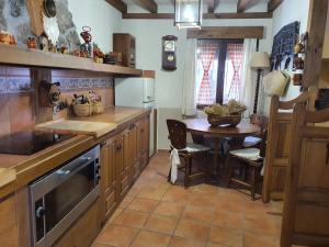 a kitchen with a table and a dining room at El lagar de Lolo in Hontanares de Eresma