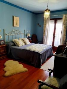 1 dormitorio con 1 cama en una habitación azul en El lagar de Lolo, en Hontanares de Eresma