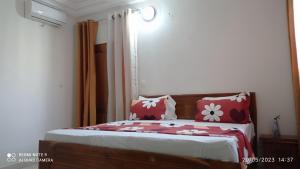Schlafzimmer mit einem Bett mit roten und weißen Kissen in der Unterkunft Chez Mamanta in St. Louis