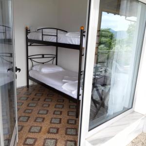 a room with two bunk beds next to a sliding glass door at Odysseas in Stavros