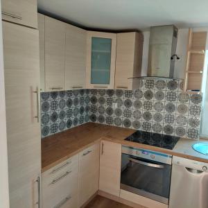 a kitchen with wooden cabinets and a stove top oven at Dom wypoczynkowy w lesie nieopodal jeziora in Szteklin