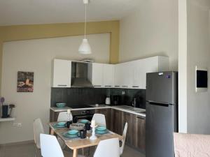 kuchnia ze stołem, krzesłami i lodówką w obiekcie Polychrono Apartments w mieście Polychrono