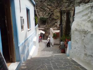 a woman standing on a street in an alley at Olympos apt with amazing mountain view in Olympos