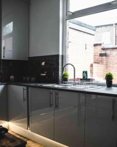 Comfortable Home In Bolton في Farnworth: طاولة مطبخ مع حوض ونافذة