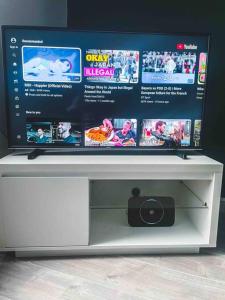 a flat screen tv sitting on top of a white stand at Comfortable Home In Bolton in Farnworth