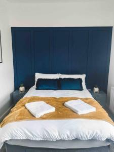 uma cama grande com duas toalhas em cima em Comfortable Home In Bolton em Farnworth