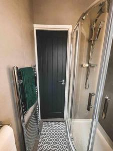 a shower with a glass door in a bathroom at Comfortable Home In Bolton in Farnworth