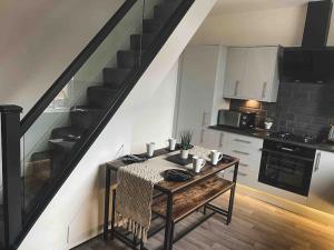 a small kitchen with a table and a staircase at Comfortable Home In Bolton in Farnworth