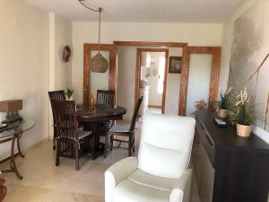 a living room with a table and a white chair at Apartment RoSol Albir Playa in Albir
