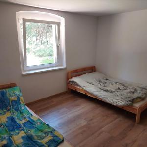 a small bedroom with a bed and a window at Dom wypoczynkowy w lesie nieopodal jeziora in Szteklin