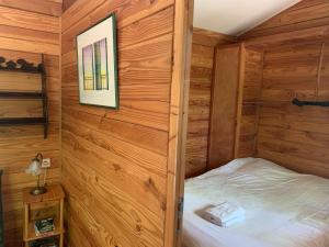 a bedroom with a bed in a wooden cabin at Chalets & Camping Villa Mayari in Escosse