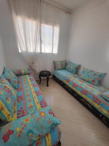 uma sala de estar com duas camas e um sofá em Maison de vacances avec vue sur mer proche Tanger em Alcácer-Ceguer