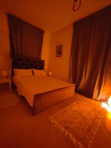 um quarto com uma cama e um tapete e cortinas em Maison de vacances avec vue sur mer proche Tanger em Alcácer-Ceguer