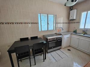 uma cozinha com uma mesa e um fogão forno superior em Maison de vacances avec vue sur mer proche Tanger em Alcácer-Ceguer