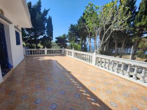 uma varanda de uma casa com uma cerca branca em Maison de vacances avec vue sur mer proche Tanger em Alcácer-Ceguer