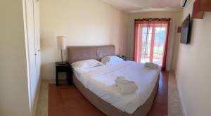 Schlafzimmer mit einem Bett mit weißer Bettwäsche und einem Fenster in der Unterkunft Vilamoura Marina Lake in Vilamoura
