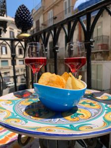 a bowl of bread on a table with two glasses of wine at La Giara in Palermo
