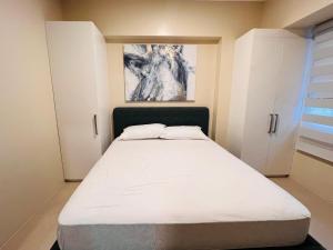 a bedroom with a bed and a painting on the wall at * * *H Incomparable Value in Iloilo City +17 photos