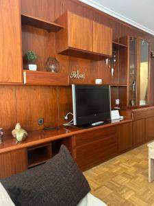 a living room with a television on a wooden desk at Apartamento a 10 minutos de la Calle Laurel in Logroño