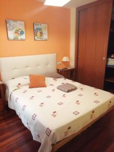 1 dormitorio con 1 cama con edredón blanco en Náutico Ribeira, en Ribeira