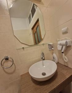 a bathroom with a white sink and a mirror at Apartament Central Traian Moșoiu , Parcare proprie in Cluj-Napoca +47 photos