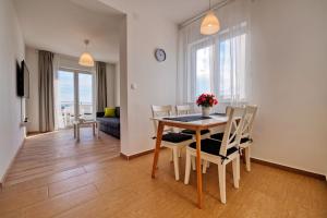 ein Esszimmer und ein Wohnzimmer mit Tisch und Stühlen in der Unterkunft Rock Apartments II in Novalja + 16 Fotos