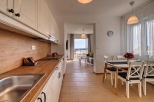 a kitchen with a sink and a table with chairs at Rock Apartments II in Novalja