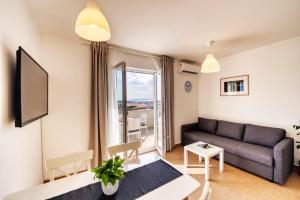 ein Wohnzimmer mit Couch und großem Fenster in der Unterkunft Rock Apartments II in Novalja