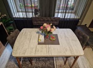 a wooden table with a vase of flowers on it at Apartament Central Traian Moșoiu , Parcare proprie in Cluj-Napoca