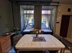 a dining room table with a vase of flowers on it at Apartament Central Traian Moșoiu , Parcare proprie in Cluj-Napoca