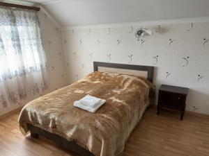 a bedroom with a bed with a blanket on it at Chkalovka guest house with Sevan view in Sevan