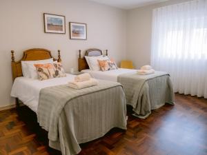 a bedroom with two beds with towels on them at Pontes Guest House in Arcozelo