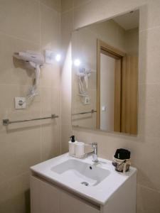 a bathroom with a sink and a mirror at Pontes Guest House in Arcozelo