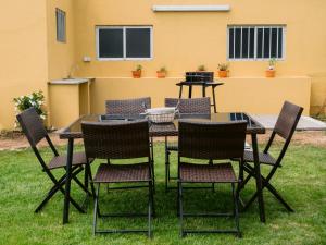 a patio table and chairs in the grass at Pontes Guest House in Arcozelo