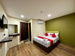 a bedroom with a bed and a green wall at Hotel MSP in Kuala Lumpur