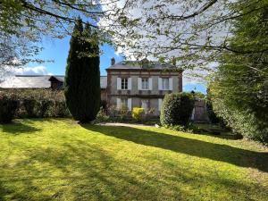 ein Haus mit einem großen Garten mit einem Baum in der Unterkunft ‘L’ éditeur’ - Maison de Maître Honfleuraise. in La Rivière Saint Sauveur