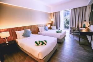 卡瓦延市The Maximilian Hotel的有两张床和一张书桌的酒店房间