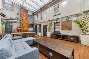 uma sala de estar com um sofá e uma mesa em London Plane Backpackers em Sydney