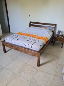 a wooden bed sitting on top of a floor at Villa Odette in Beauséjour