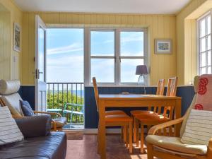 a living room with a table and chairs and a window at The Moorings in Staithes